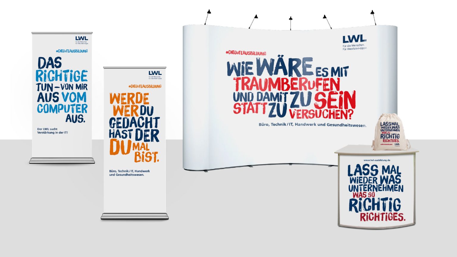 Werbedisplay mit einer Rückwand, zwei Bannern und einem Thekenelement, auf denen in Blau und Orange deutsche Texte zu sehen sind, die zur Berufsorientierung in den Bereichen Bildung, Gesundheit und IT anregen. Das Design besticht durch markante, verspielte Schriftarten.