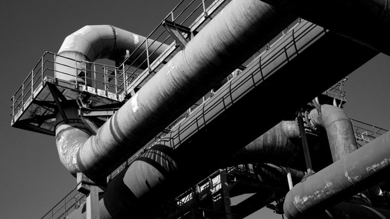Ein schwarz weiss Foto vom Ruhrgebiet, Rohre und Industrie verzweigt.