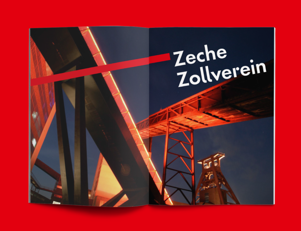 Doppelseite einer Zollverein-Broschüre über die Zeche, große Fotografie der Industrieanlagen, Maschinen und Förderturm.